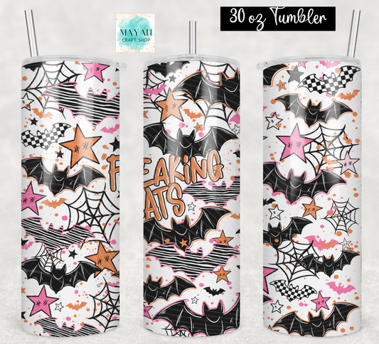 Three 30 oz tumblers with clear straws, featuring a Halloween-themed print with bats, spiderwebs, stars, clouds, and the words 'FREAKING BATS' in orange. The background is a light textured gray.