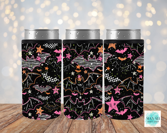 Three black can coolers with a Halloween-themed pattern of bats, stars, and checkered flags, shown on silver aluminum cans against a blurred bokeh background and wooden surface.