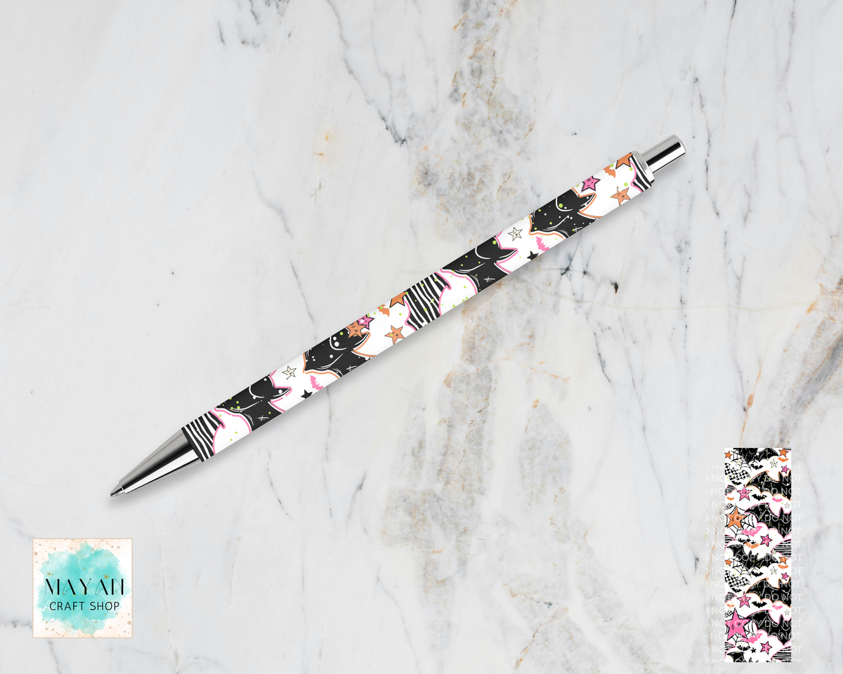 A retractable ballpoint pen with a black barrel decorated with a pink, white, and gold floral pattern, displayed diagonally on a white marble background. A small inset image in the bottom-right shows a close-up of the pattern.