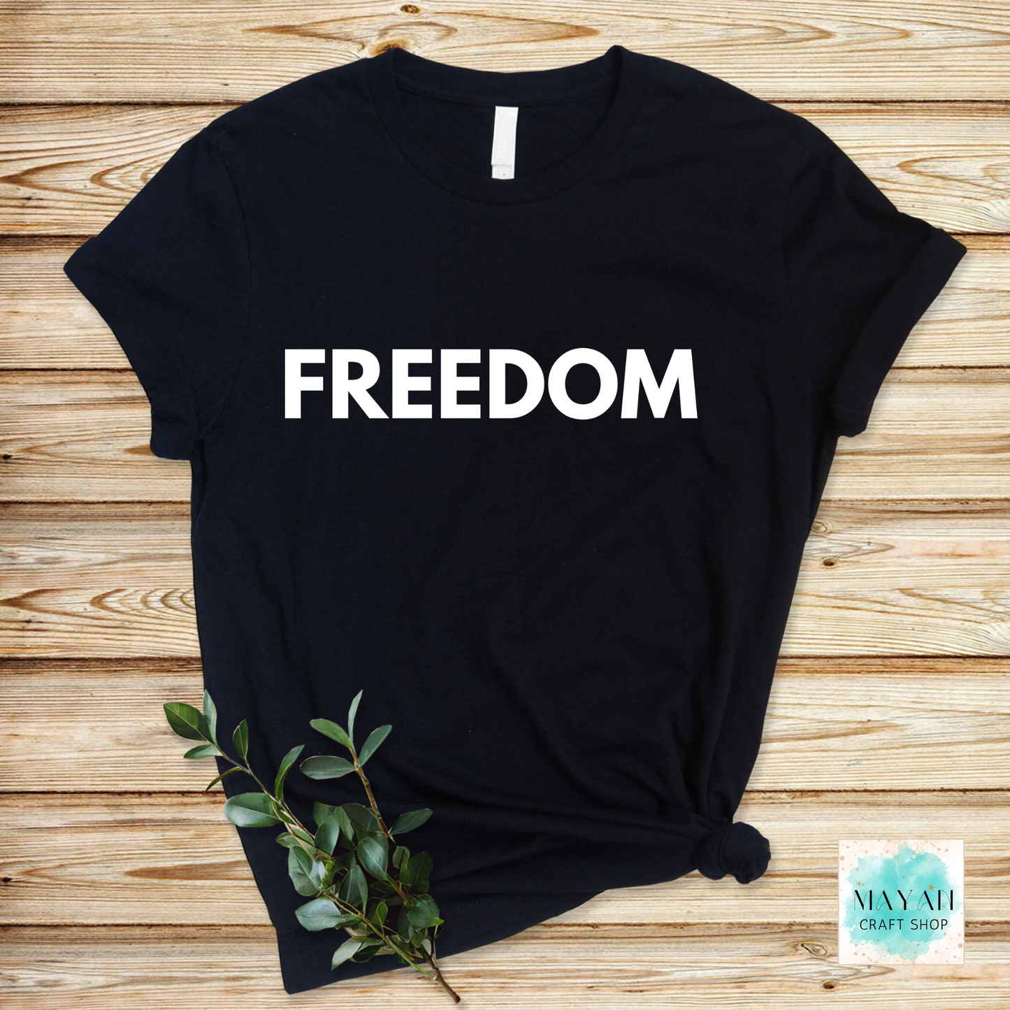 Black t-shirt with 'FREEDOM' text on a wooden surface