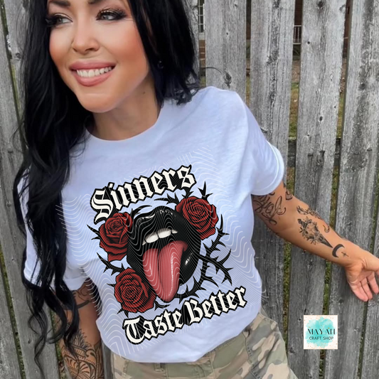 Woman wearing a white t-shirt with a graphic design and text, standing against a wooden fence.
