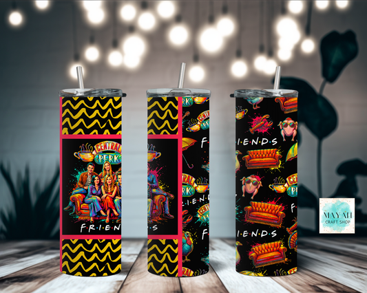 Three tumblers with tv show themed designs on a wooden surface with blurred lights in the background.