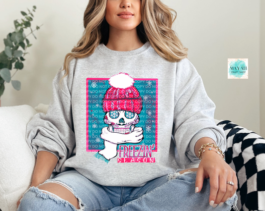 Person wearing a gray sweatshirt with a colorful graphic design sitting on a couch.