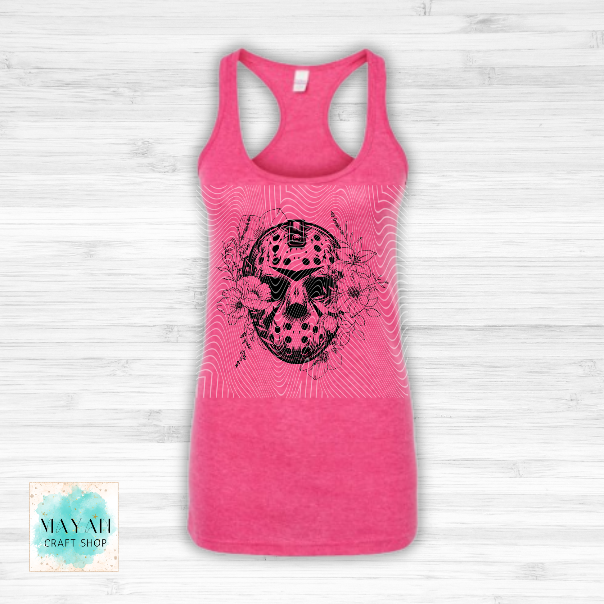 Pink tank top with black skull design on a light wooden background