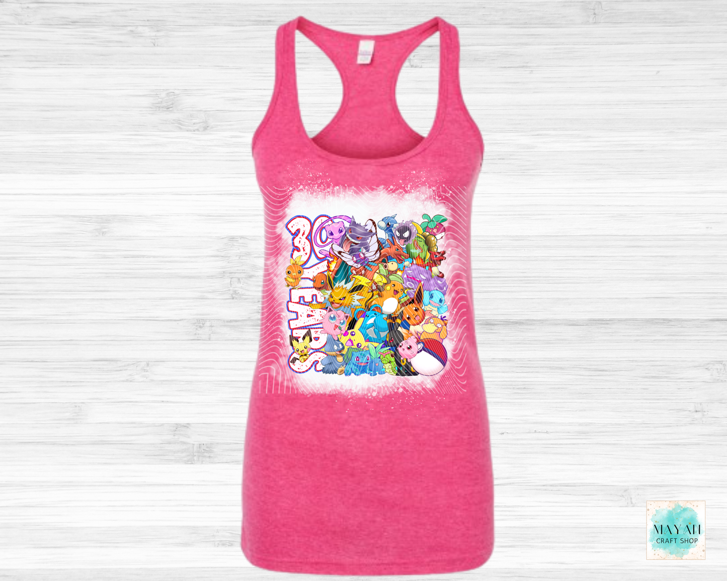 Pink tank top with colorful graphic design on a white wooden background