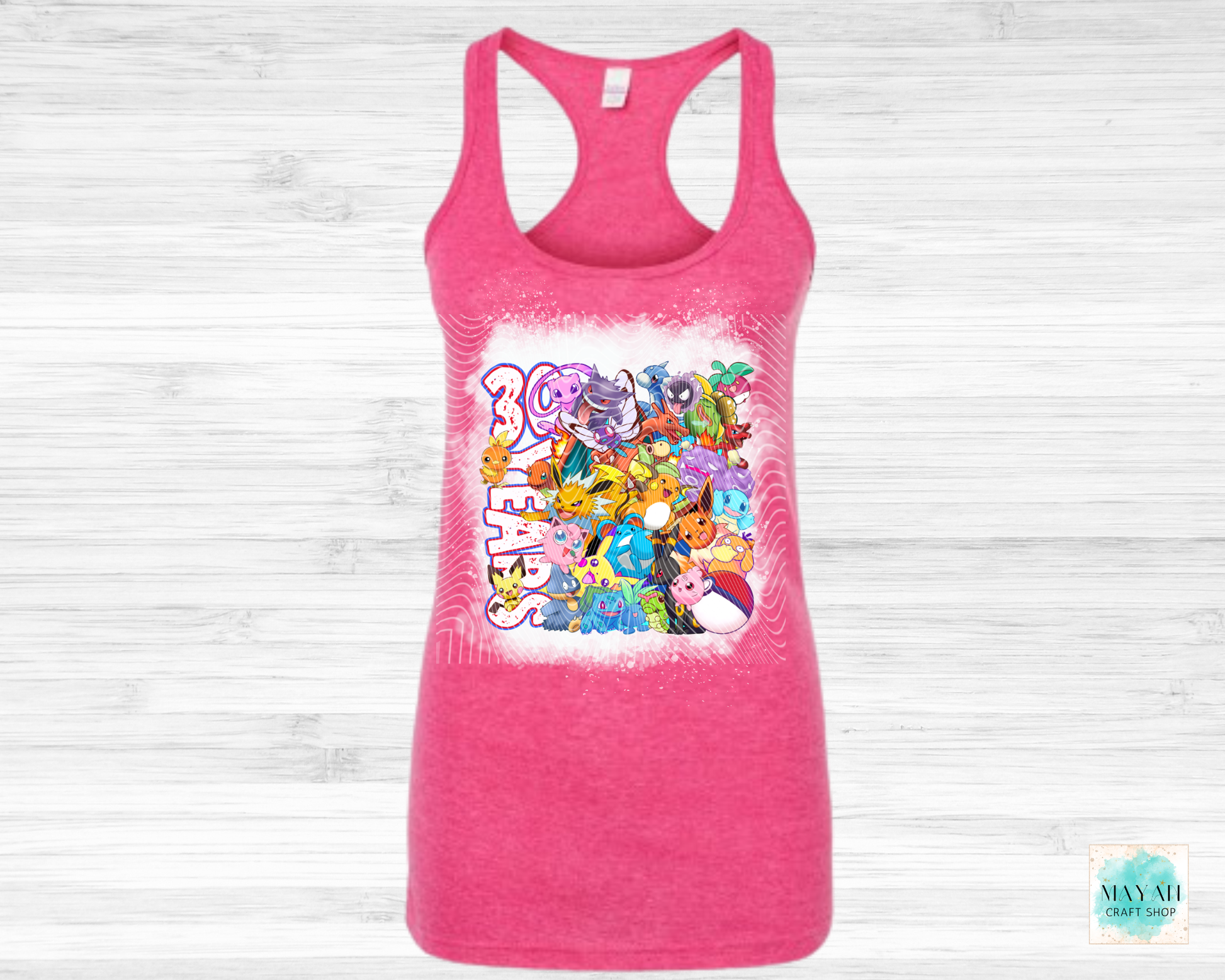 Pink tank top with colorful graphic design on a white wooden background