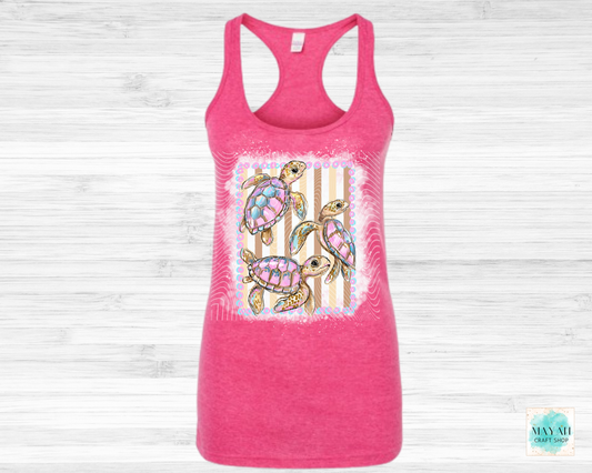 Pink tank top with a colorful turtle design on a light wooden background
