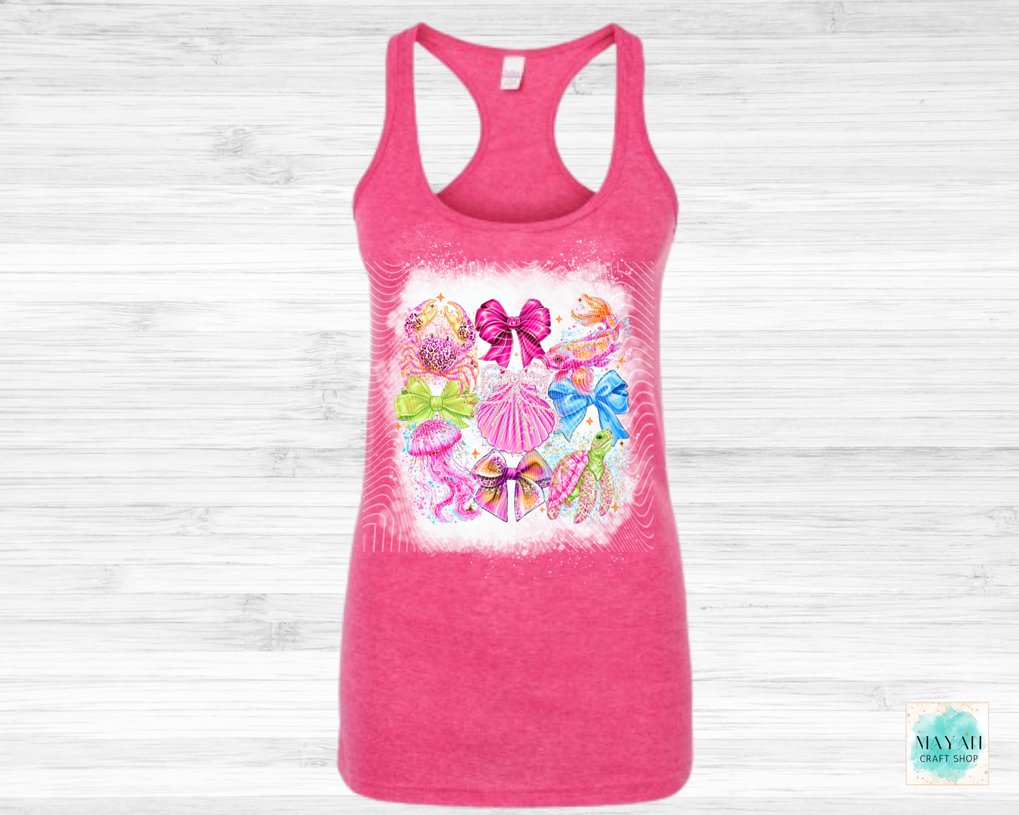 Pink tank top with colorful bow design on a light wooden background