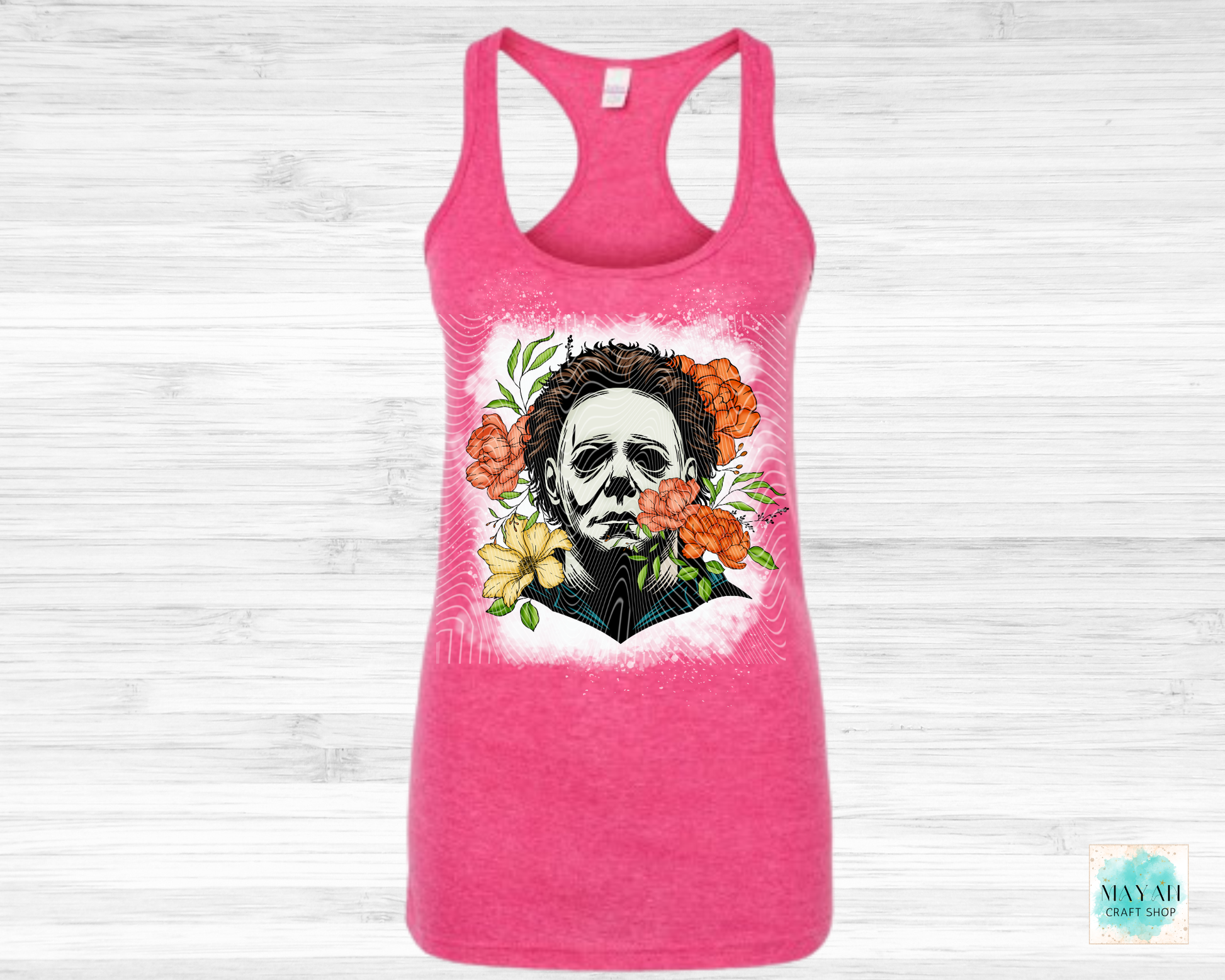 Pink tank top with a graphic design of a face surrounded by flowers on a white background