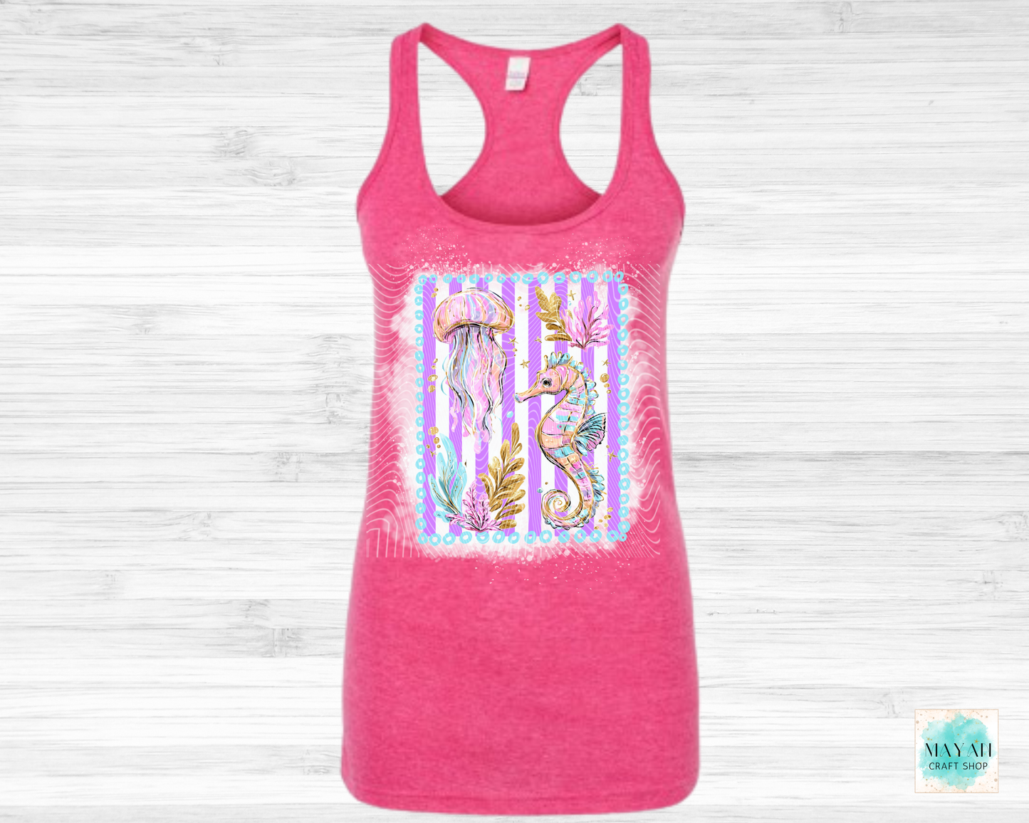 Pink tank top with a colorful seahorse design on a light wooden background