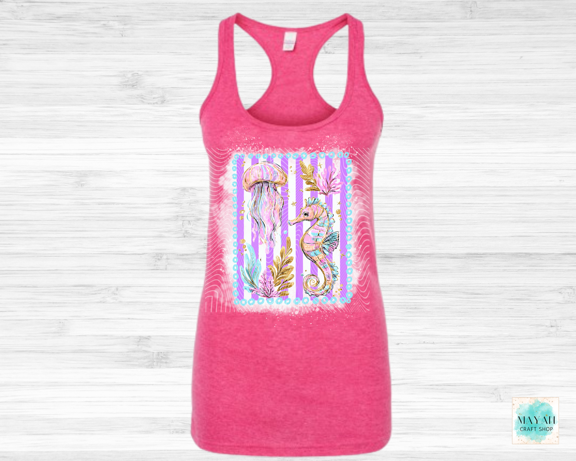 Pink tank top with a colorful seahorse design on a light wooden background