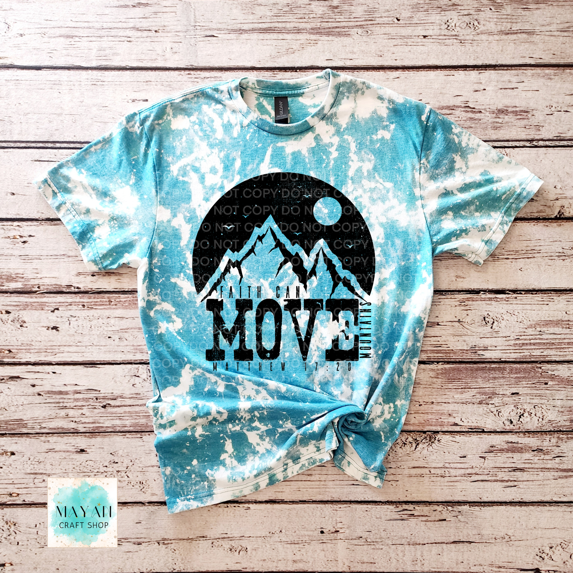 Tie-dye t-shirt with mountain graphic and 'I Want to Move' text on a wooden surface.