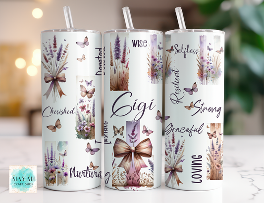 Three tumblers with floral and butterfly designs and motivational phrases on a blurred background.
