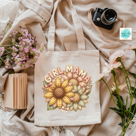 Tote bag with 'Girl Mama' design surrounded by flowers and a camera on a soft fabric background