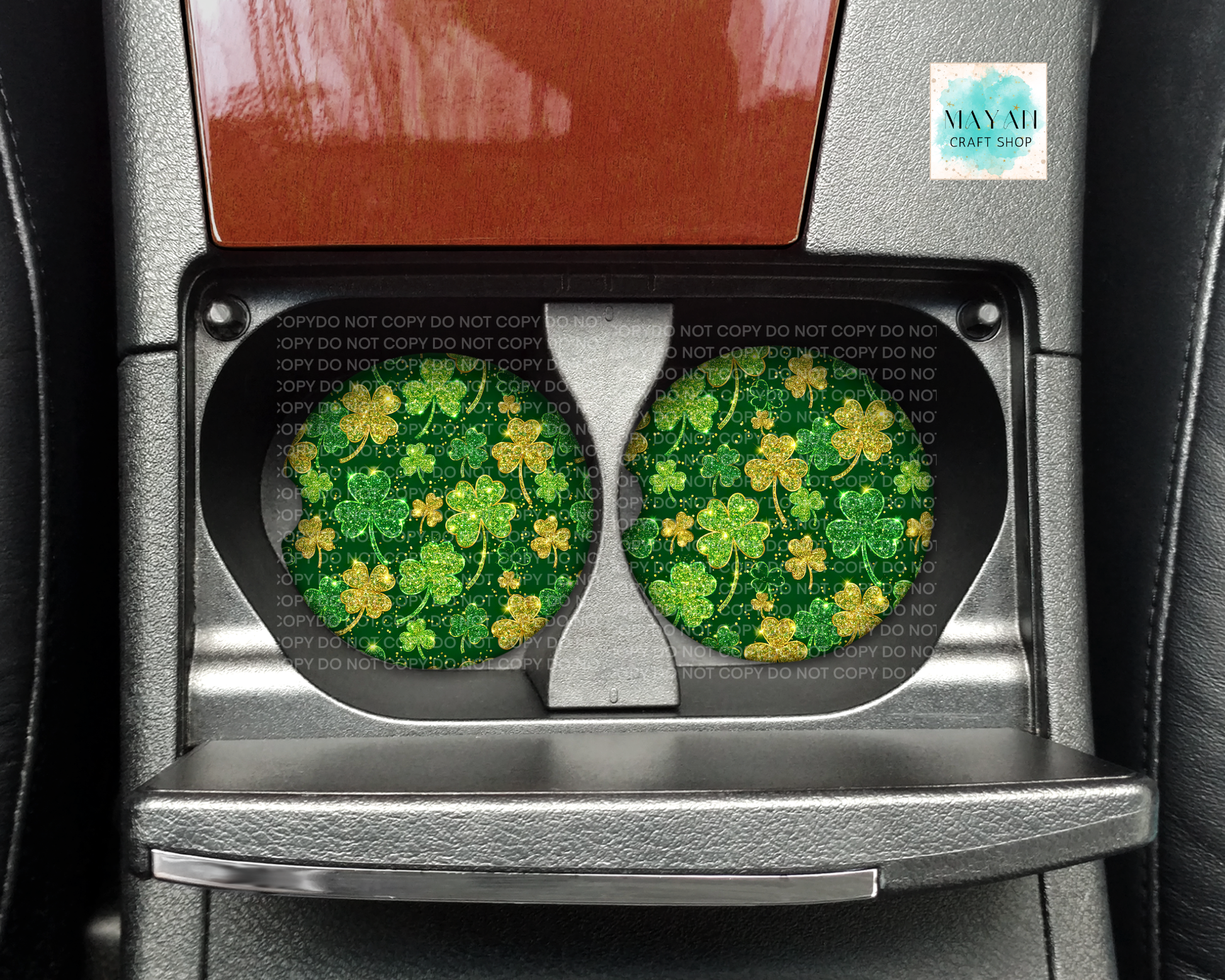 Car cup holders with green shamrock design coasters on a vehicle interior.