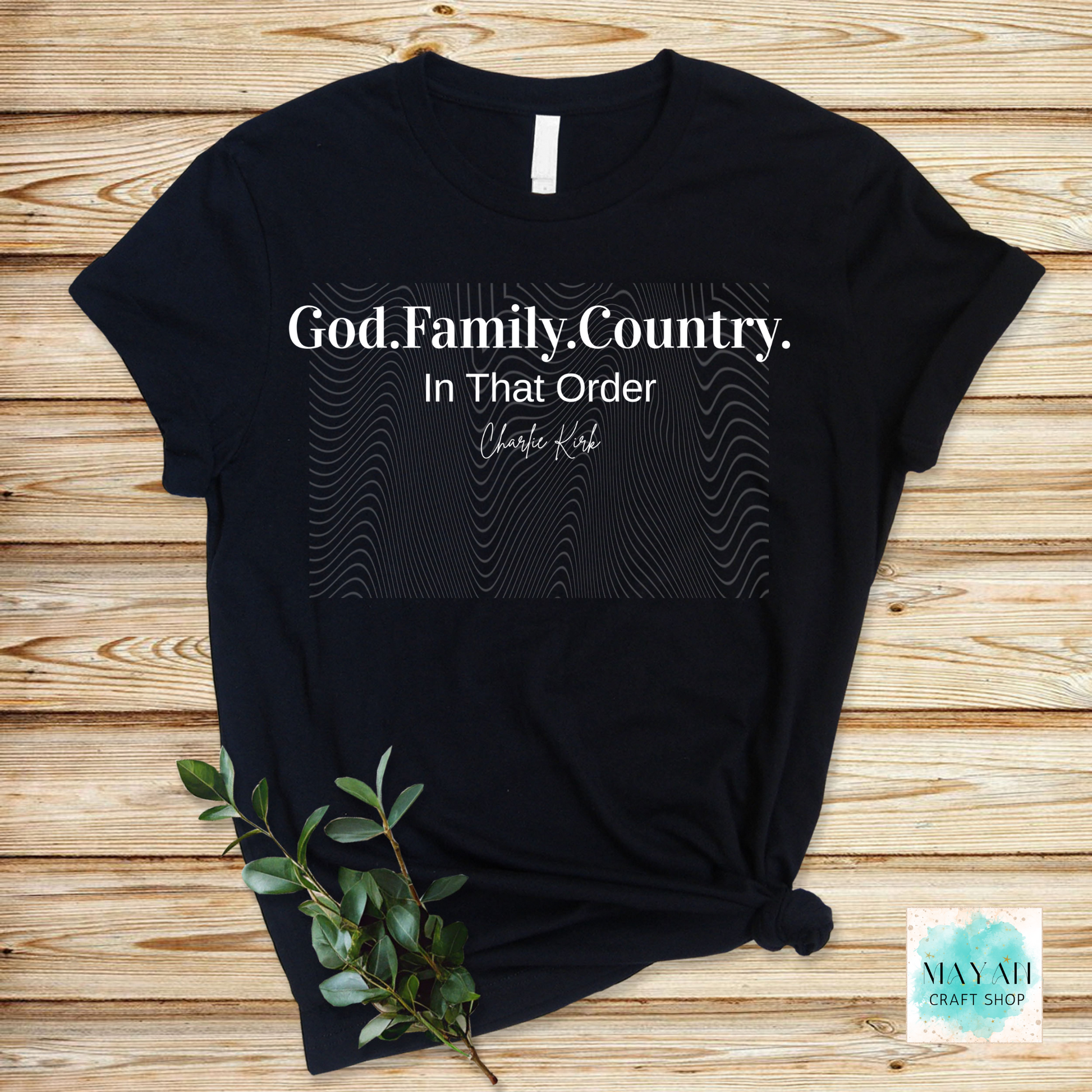 Black t-shirt with 'God. Family. Country. In That Order' text on a wooden surface