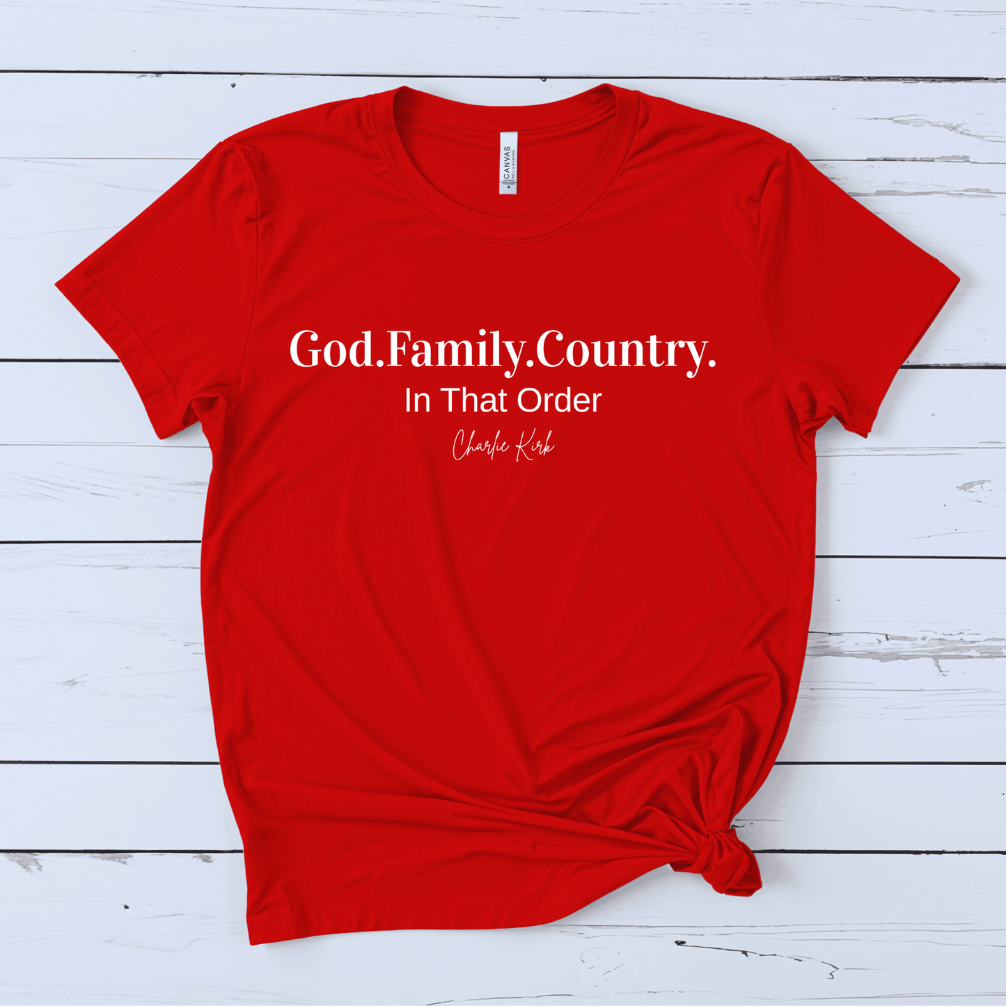 Red t-shirt with white text on a wooden surface