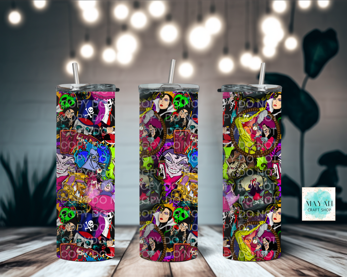 Three colorful tumblers with a collage design on a wooden surface with blurred lights in the background.