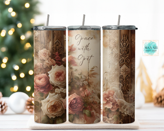 Three floral-themed tumblers with decorative patterns and text on a white surface with a blurred Christmas tree background.