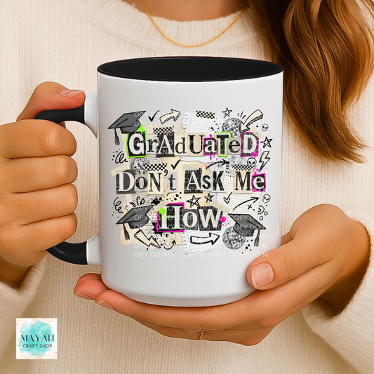 Person holding a mug with 'Graduated Don't Ask Me How' text design.