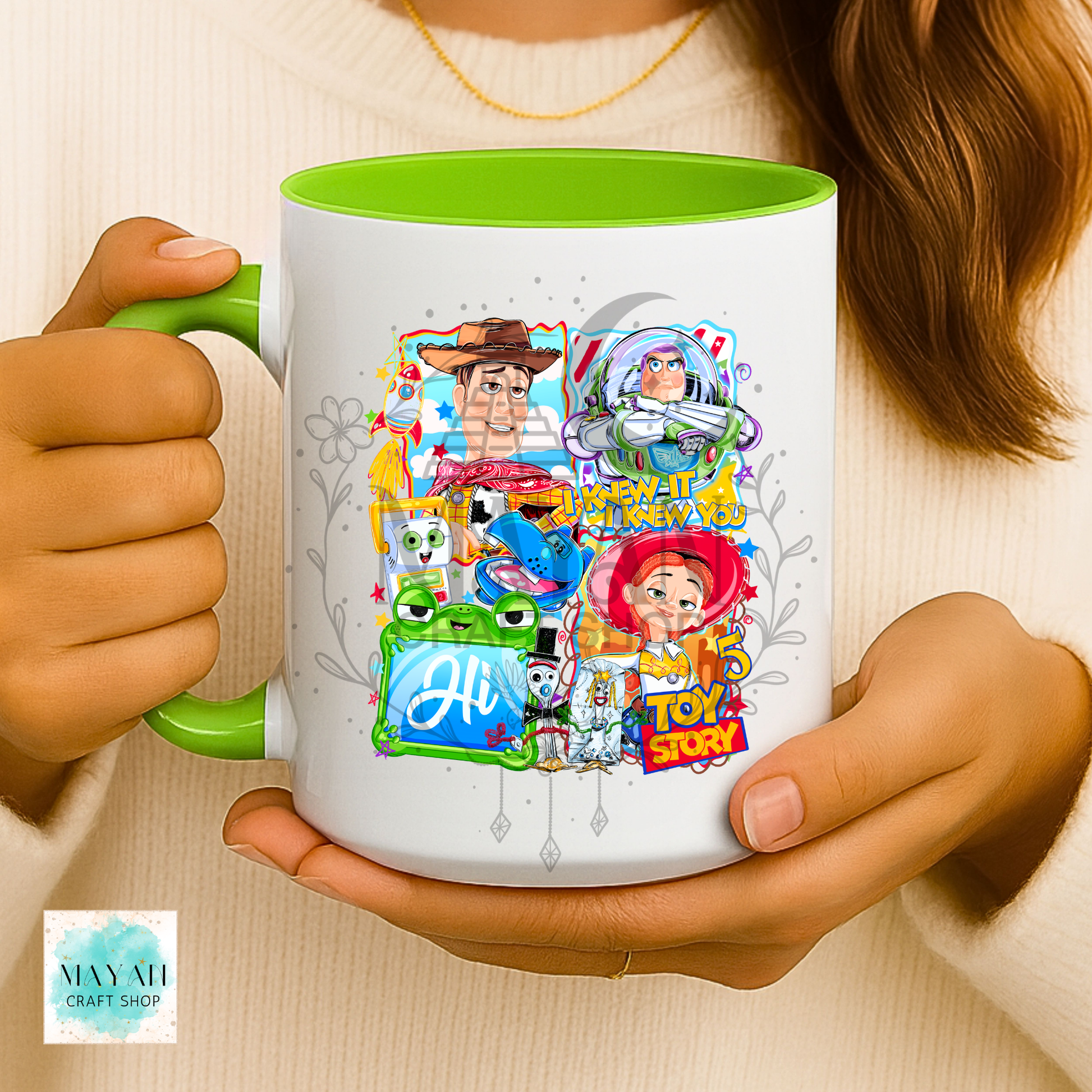Person holding a mug with character designs on a light background