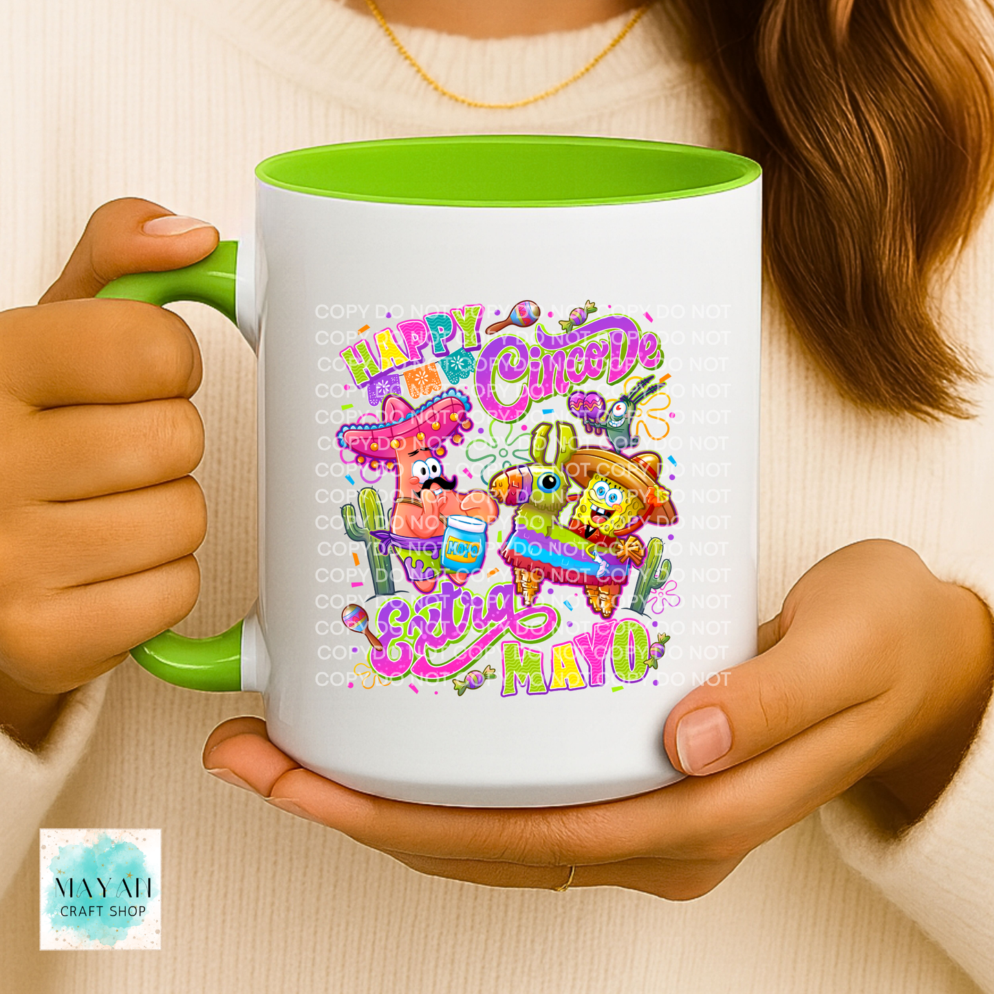 Person holding a mug with colorful design and text, featuring cartoon characters and festive elements.