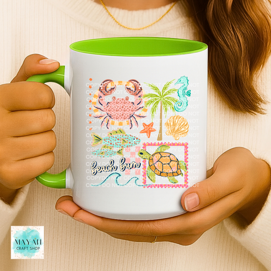 Person holding a mug with beach-themed design featuring crabs, palm trees, and turtles.