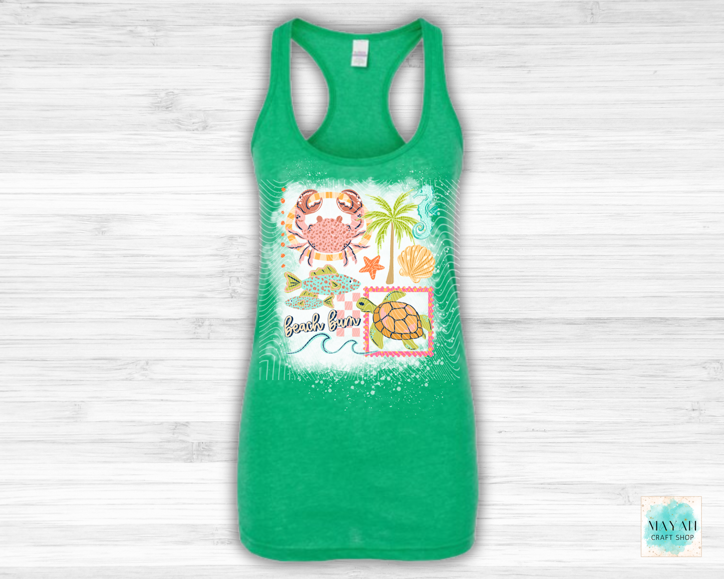 Green tank top with beach-themed design on a light wooden background