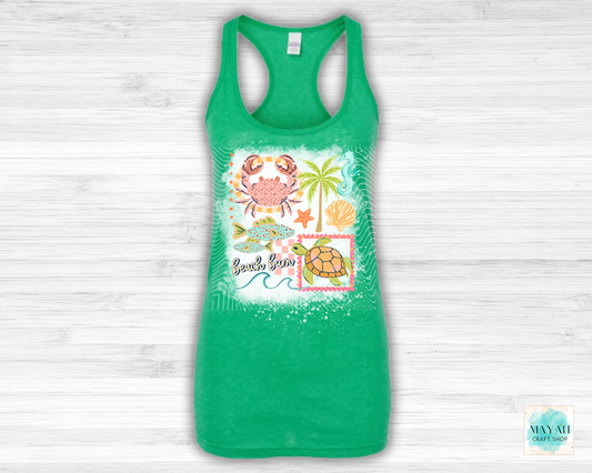 Green tank top with beach-themed design on a light wooden background