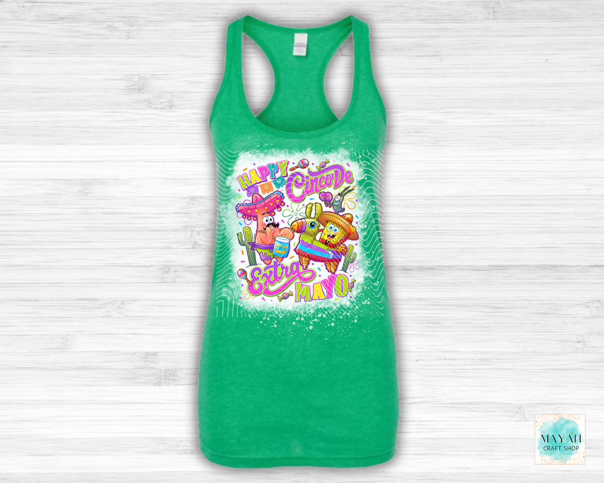 Green tank top with colorful graphic design on a light wooden background