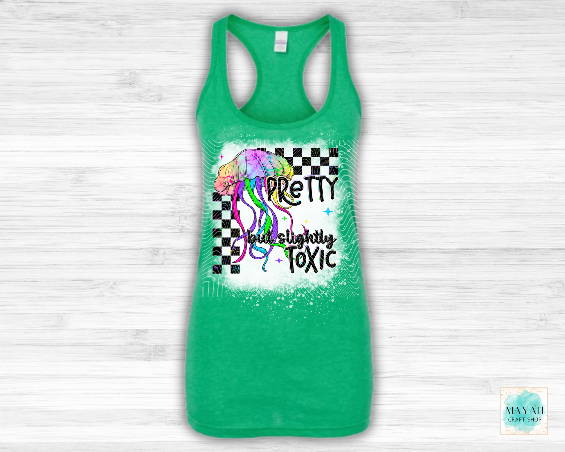 Green tank top with colorful graphic and text on a white wooden background