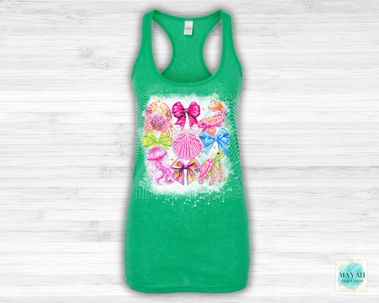 Green tank top with colorful bow and shell design on a light wooden background