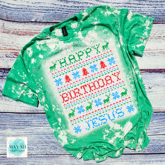 Green and white distressed t-shirt with 'Happy Birthday Jesus' text on a wooden surface