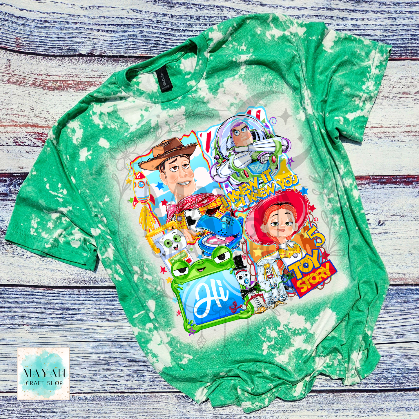 Green tie-dye t-shirt with character graphics on a wooden surface