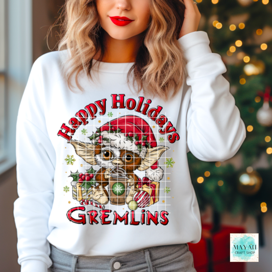 Person wearing a white sweatshirt with 'Happy Holidays' design in front of a Christmas tree.