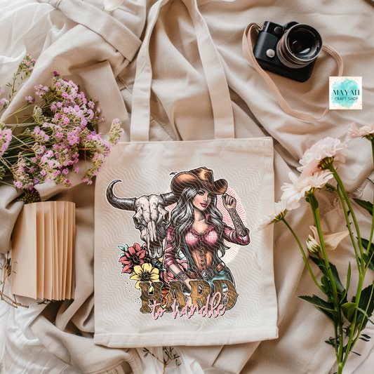 Tote bag with a design of a woman in a cowboy hat and bull skull, surrounded by flowers and a camera.