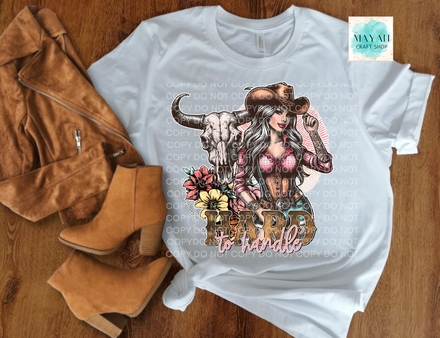 White t-shirt with graphic design featuring a woman, skull, and text on a wooden surface with boots and a jacket.