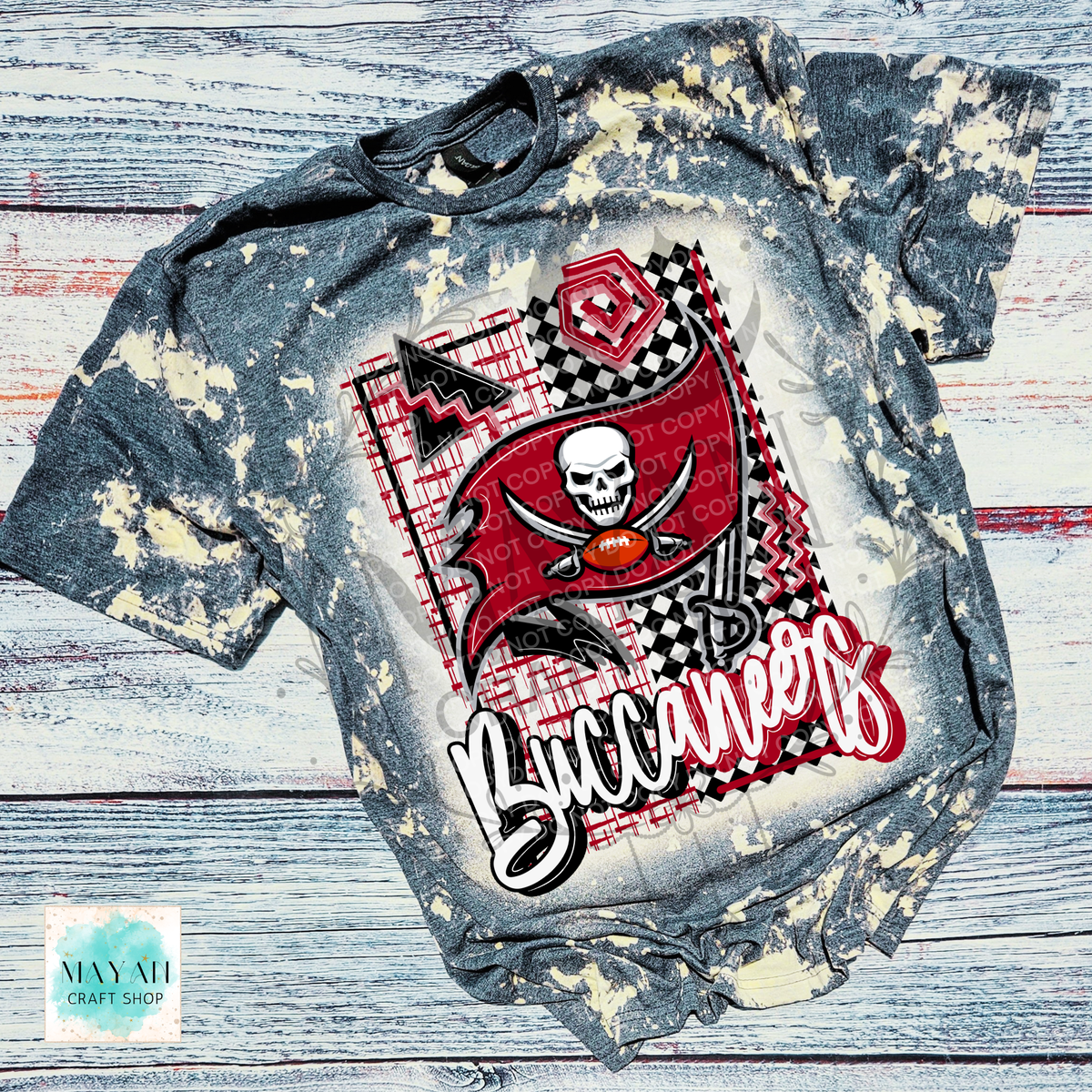 A short-sleeve graphic T-shirt laid flat on a distressed whitewashed wood background. The shirt is a heather charcoal bleached shirt featuring a red pirate flag, skull, crossed swords, a football shirt.