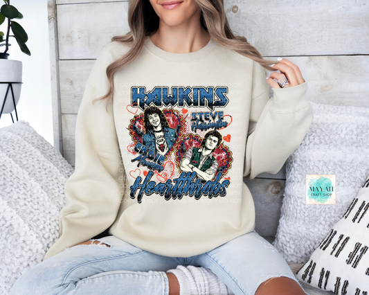 Person wearing a cream sweatshirt with 'Heartthrobs' graphic design.