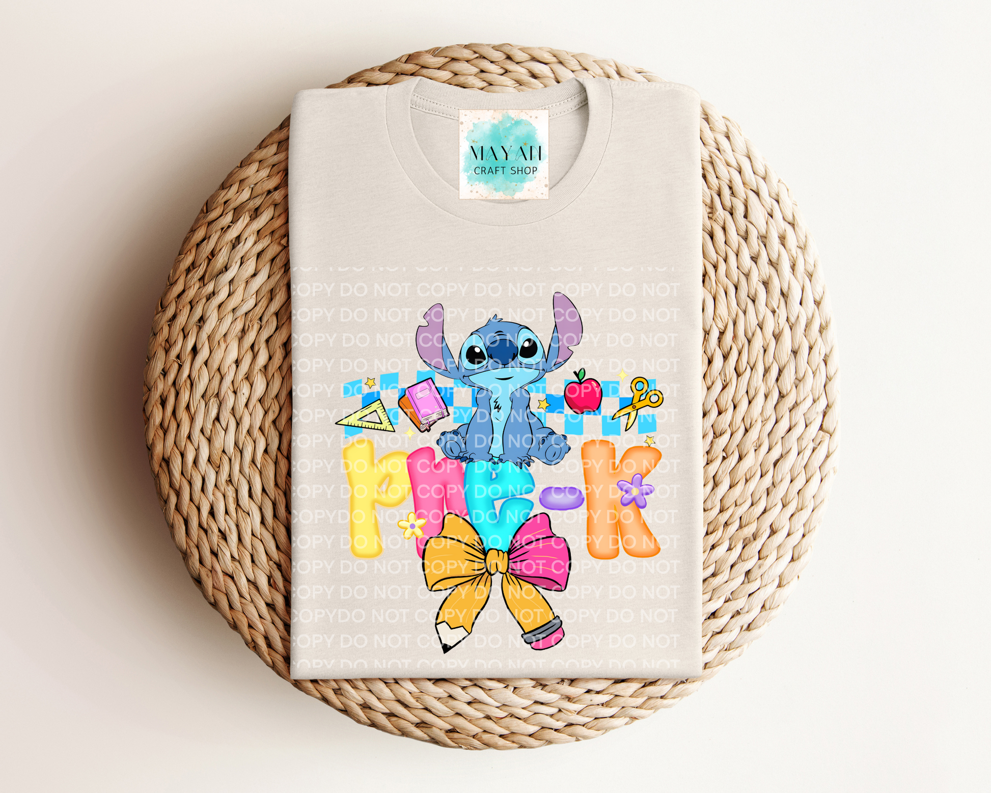 Heather dust shirt with cartoon character and colorful text on a woven mat.