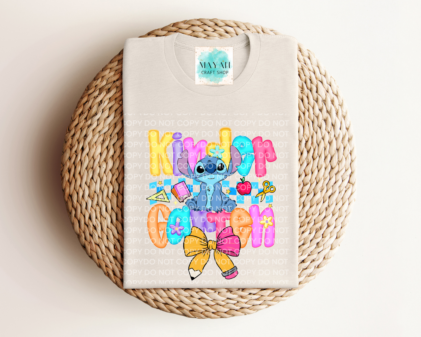 Heather dust shirt with colorful design featuring a character, on a woven round mat.