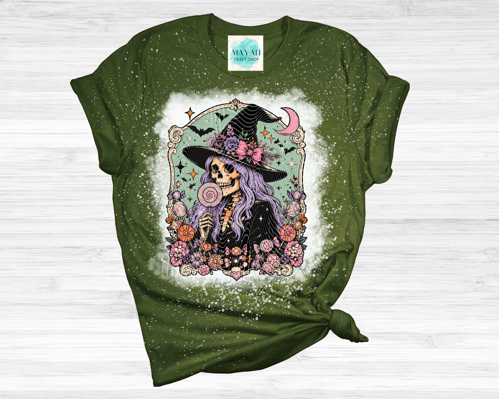 Green t-shirt with a skeleton wearing a witch hat and flowers design on a white background