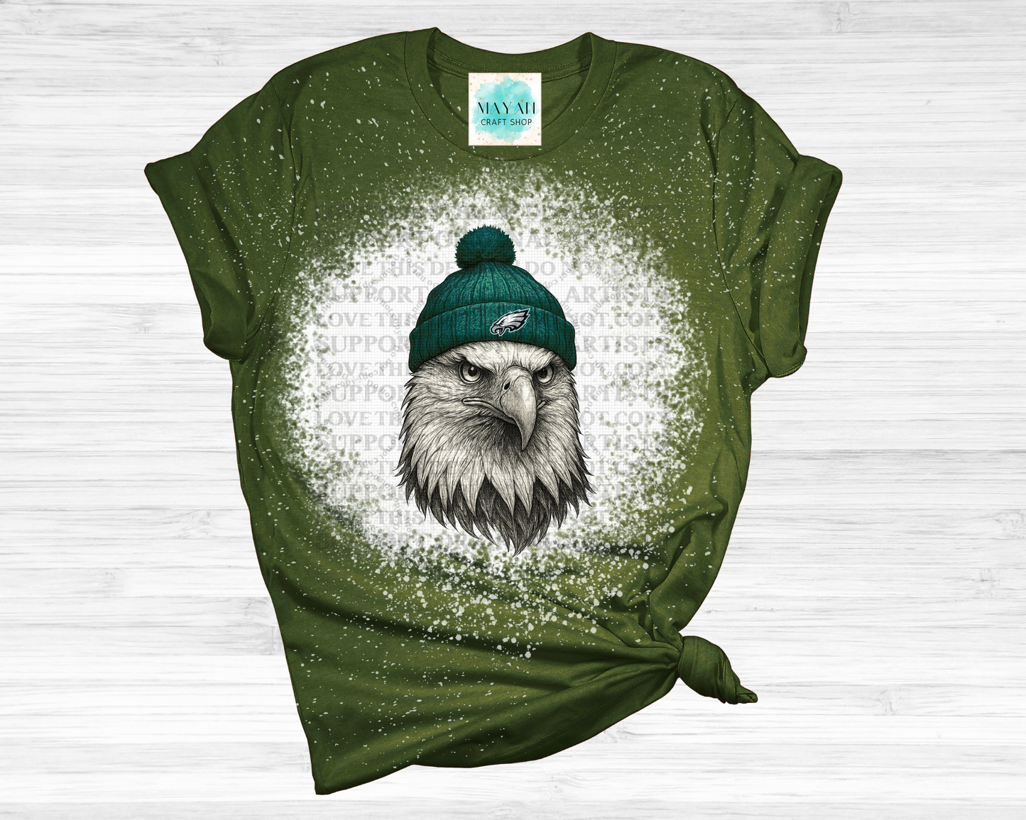 Green t-shirt with an eagle wearing a green beanie on a white background