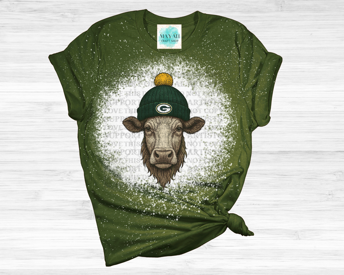 Green t-shirt with a cow wearing a green hat graphic on a white background