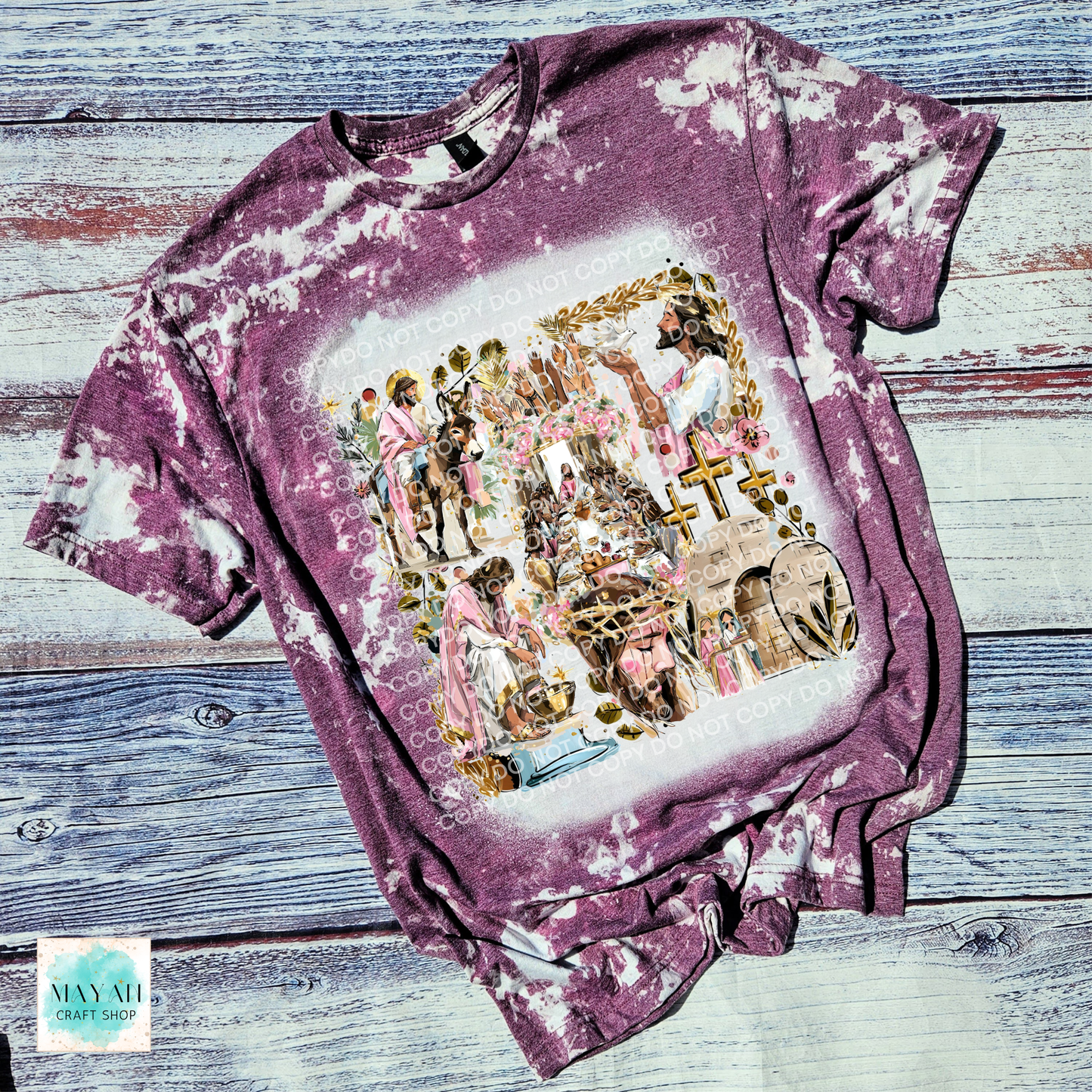 Bleached maroon t-shirt with a colorful graphic design on a wooden surface