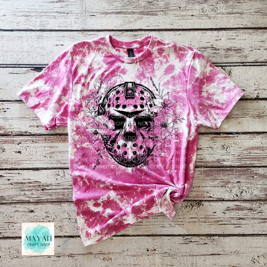Pink tie-dye t-shirt with a black skull design on a wooden surface