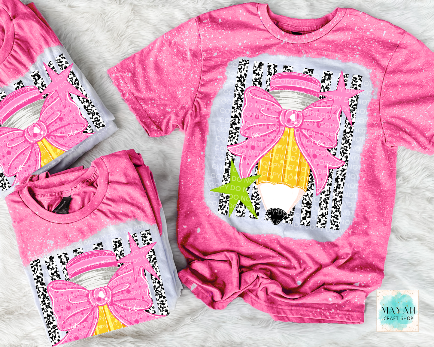 Three pink bleached t-shirts with a graphic, arranged on a white faux fur background. The shirts feature a large pink bow, yellow striped hat, and black-and-white zebra pattern.