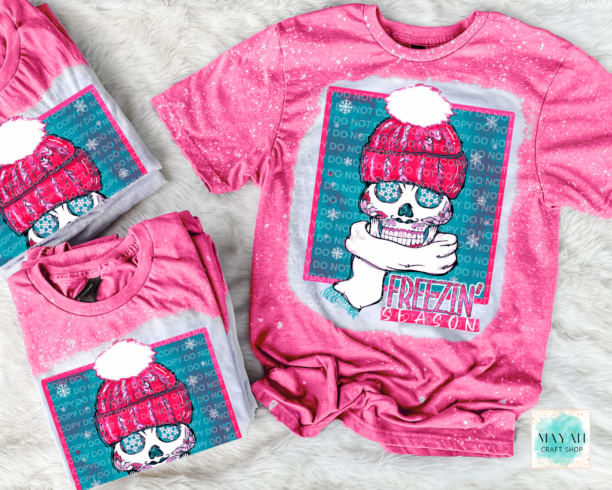 Pink t-shirt with a graphic design of a skull wearing a pink beanie and text 'Freezing season', displayed on a white surface.