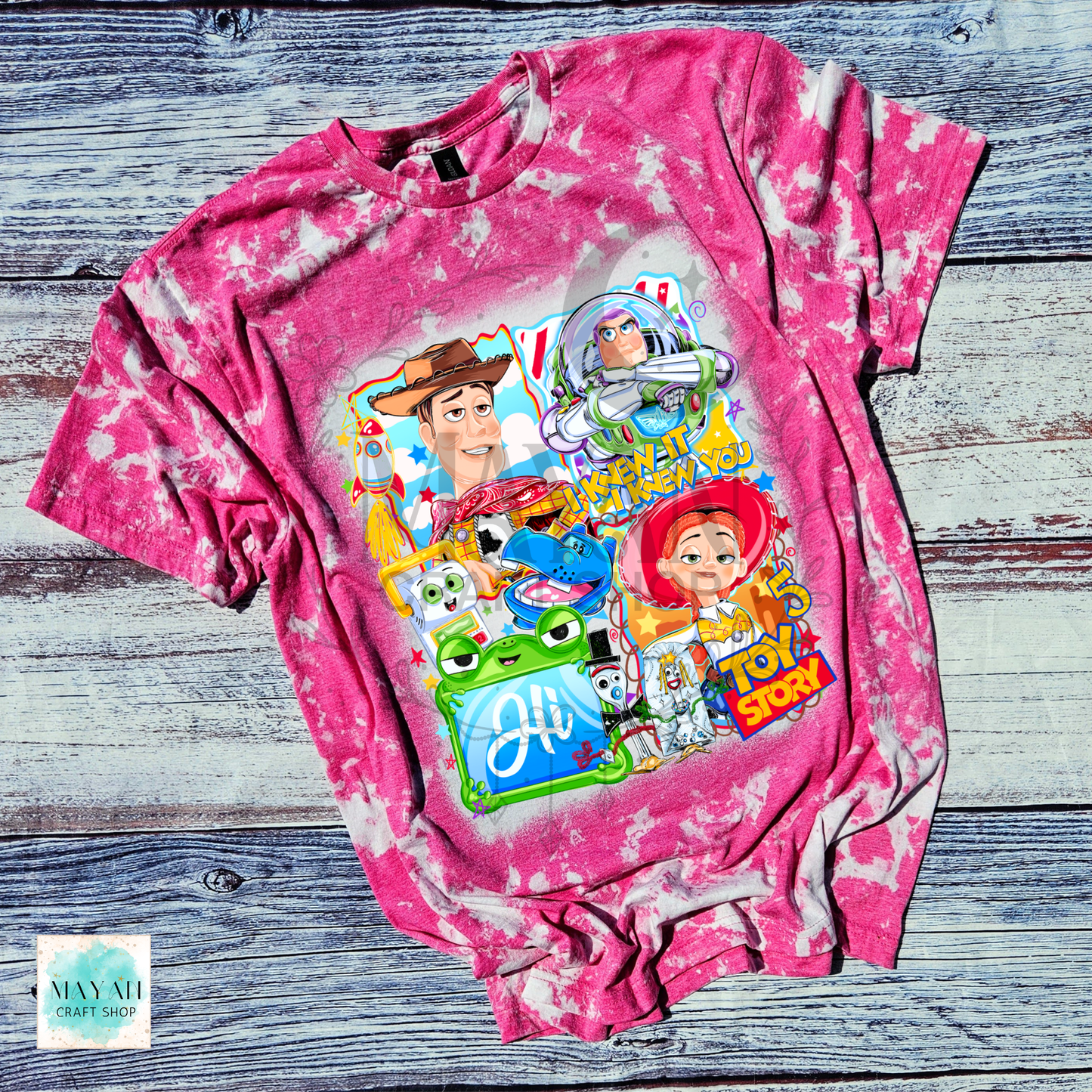 Pink tie-dye t-shirt with character graphics on a wooden surface
