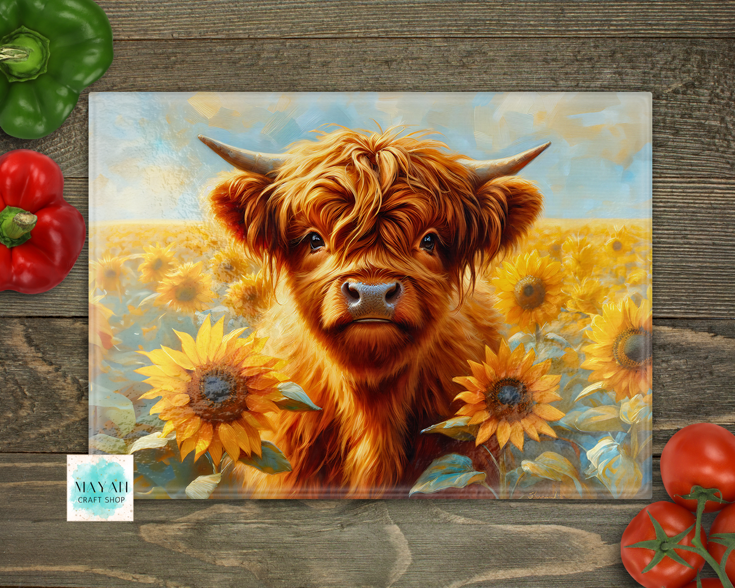 Painting of a Highland cow in a sunflower field on a wooden surface with vegetables around.